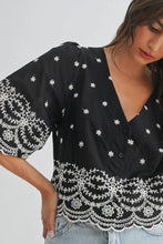 Load image into Gallery viewer, Black blouse with white floral patterns on a plain background