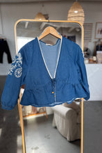 Load image into Gallery viewer, Blue embroidered jacket on a hanger in front of a mirror
