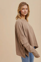 Load image into Gallery viewer, Woman wearing a beige sweater and blue jeans against a beige background