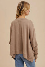 Load image into Gallery viewer, Woman wearing a beige sweater and blue jeans against a beige background