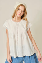Load image into Gallery viewer, Woman wearing a white blouse with lace details and a blue skirt on a beige background