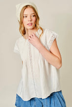 Load image into Gallery viewer, Woman wearing a white lace top and blue pants against a beige background
