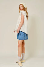 Load image into Gallery viewer, Woman wearing a white sleeveless top and blue denim skirt on a plain background