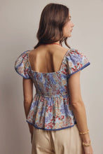 Load image into Gallery viewer, Woman wearing a floral blouse with puffed sleeves against a neutral background