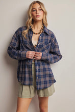 Load image into Gallery viewer, Woman wearing a blue plaid shirt and green shorts against a plain background