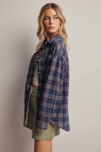 Load image into Gallery viewer, Woman wearing a blue plaid shirt over a beige top and green shorts on a plain background