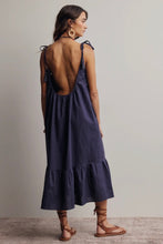 Load image into Gallery viewer, Woman wearing a dark blue dress with a backless design on a plain background