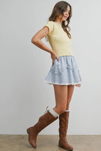 Load image into Gallery viewer, Woman wearing a yellow top, plaid skirt, and brown boots on a plain background