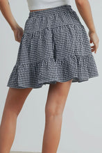 Load image into Gallery viewer, Black and white checkered skirt worn by a person on a plain background