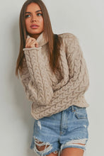 Load image into Gallery viewer, Woman wearing a beige cable knit sweater and denim shorts against a plain background