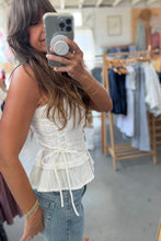 Load image into Gallery viewer, Woman taking a mirror selfie wearing a white top and blue jeans in a clothing store.