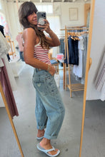 Load image into Gallery viewer, Woman taking a mirror selfie in a clothing store wearing a striped tank top and jeans.