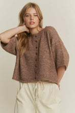 Load image into Gallery viewer, Woman wearing a brown knitted cardigan over a beige top with white pants on a plain background