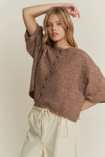 Load image into Gallery viewer, Woman wearing a brown knitted cardigan over a beige top with white pants on a plain background