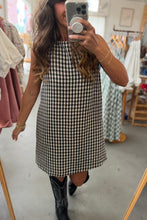 Load image into Gallery viewer, Woman taking a mirror selfie wearing a black and white checkered dress in a store.