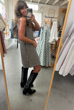 Load image into Gallery viewer, Woman taking a mirror selfie wearing a checkered dress and black boots in a clothing store.