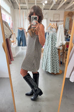 Load image into Gallery viewer, Person wearing a checkered dress and black knee-high boots in a clothing store.