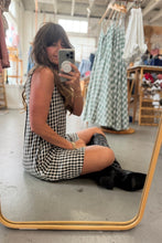 Load image into Gallery viewer, Woman taking a mirror selfie wearing a checkered dress and black boots in a clothing store.