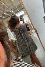 Load image into Gallery viewer, Woman taking a mirror selfie wearing a black and white checkered dress in a store.