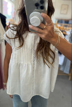 Load image into Gallery viewer, Person wearing a white blouse with lace details in a clothing store.