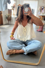 Load image into Gallery viewer, Woman taking a mirror selfie wearing a white top and light blue jeans in a casual setting.