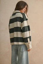 Load image into Gallery viewer, Person wearing a black and white striped shirt against a beige background