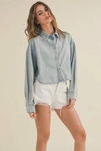 Load image into Gallery viewer, Woman wearing a light blue denim jacket and white shorts on a beige background