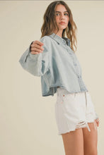 Load image into Gallery viewer, Woman wearing a light blue denim jacket and white shorts on a beige background