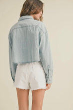 Load image into Gallery viewer, Woman wearing a light blue denim jacket and white shorts on a beige background