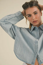 Load image into Gallery viewer, Woman wearing a light blue denim shirt against a beige background