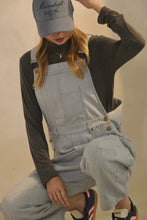 Load image into Gallery viewer, Person wearing a gray checkered overalls and a cap with a blurred background