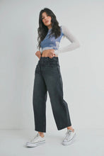 Load image into Gallery viewer, Woman wearing a blue crop top with graphic design, black high-waisted jeans, and white sneakers on a plain background