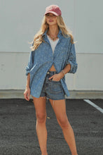 Load image into Gallery viewer, A woman stands outdoors wearing a loose blue denim button-up shirt over a white top, matching denim shorts, a pink baseball cap, and layered necklaces.