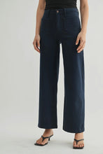 Load image into Gallery viewer, Person wearing navy blue wide-leg jeans on a light gray background