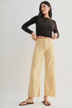 Load image into Gallery viewer, Woman wearing a black long-sleeve top and beige pants on a white background