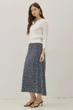 Load image into Gallery viewer, Woman wearing a white cardigan and navy floral skirt on a plain background