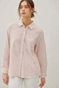 Woman wearing a light pink striped shirt against a white background