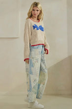 Load image into Gallery viewer, Woman wearing a patterned sweater and pants in a neutral setting