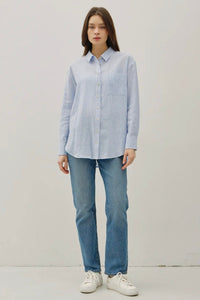 Person wearing a light blue shirt and jeans on a white background