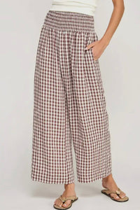 Person wearing plaid wide-leg pants on a plain background