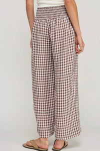 Person wearing checkered pants on a plain background