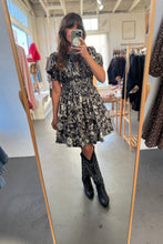 Load image into Gallery viewer, Person wearing a black and white floral dress in a clothing store.