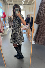 Load image into Gallery viewer, Person wearing a floral dress and black boots in a clothing store.