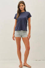 Load image into Gallery viewer, A woman modeling a short-sleeve crewneck t-shirt in navy blue and light gray drawstring shorts against a plain white studio background.
