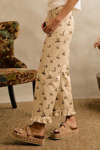 Load image into Gallery viewer, A person wearing beige wide-leg cropped pants with a small bird print, styled with platform sandals in a warm indoor setting.