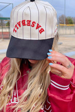 Load image into Gallery viewer, A person outdoors wearing a cream pinstripe baseball cap with red 'BASEBALL' text on the front and a dark navy brim, paired with a red varsity jacket.