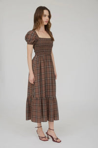 Woman wearing a brown checkered dress on a white background