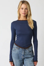 Load image into Gallery viewer, A woman modeling a navy blue long-sleeve crewneck top with contrasting brown trim at the collar, hem, and cuffs, paired with light-wash blue jeans against a light gray studio background.