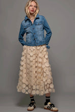 Load image into Gallery viewer, Woman wearing a denim jacket and a textured beige skirt on a gray background