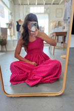 Load image into Gallery viewer, Woman in a pink checkered dress taking a mirror selfie in a room.